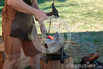 Blacksmith Working Incandescent Iron with Hammer and Anvil Stock Photo