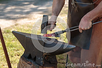 Blacksmith Working Incandescent Iron with Hammer and Anvil Stock Photo