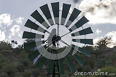 Blades of wind engine lifting water from well for watering wild animals Stock Photo