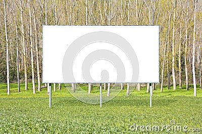 Blank advertising signboard in a countryside with forest in the background - concept with space for inserting text Stock Photo