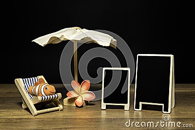 Blank black board with beach umbrella and bed with clown fish and flower Stock Photo