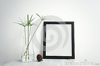 Blank Black Photo Frame and vase on table for Design Mockup Stock Photo