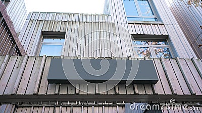 Blank black signboard mounted on weathered wooden facade of building perfectly suited for branding or advertisements Stock Photo