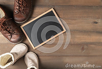 Blank blackboard with father and son brown leather boots shoes Stock Photo