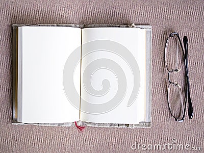 Blank book page open spread with eyeglasses on table Stock Photo