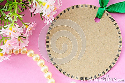 Blank brown tag circle shape and green ribbon with flower. Stock Photo