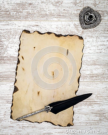 Blank burned vintage card with ink and quill on white painted oak - top view Stock Photo