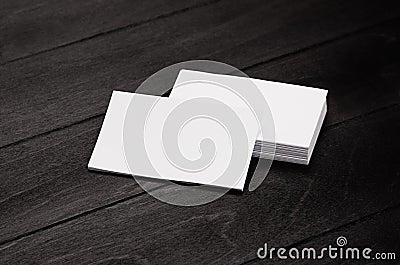 Blank corporate identity business card and stack on black stylish wood background with blur, template. Stock Photo