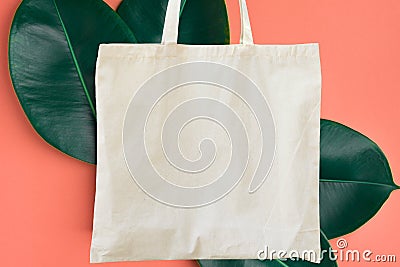 Blank cotton shite shopper tote bag on pink background with green leaves. Mock up template for product branding plastic free Stock Photo