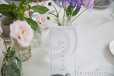 Blank Course menu paper on Party table decorated with beautiful flowers Stock Photo