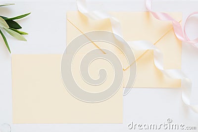 Blank cream-colored envelope with ribbons, mock up for romantic invitations, wedding design Stock Photo