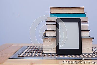 Blank eReader in front of a tower of books with bookmarks Stock Photo