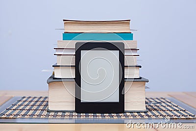 Blank eReader in front of a tower of books with bookmarks Stock Photo