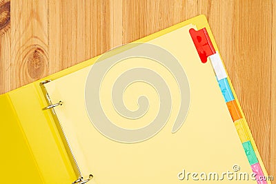 Blank file tabs in a yellow binder on wood desk mockup Stock Photo