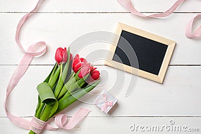 Blank greeting card with red tulips flowers on white wooden table. Romantic wedding card, greeting card for womans or mothers day, Stock Photo