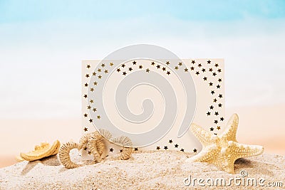 Blank greeting card, starfish, heart in sand against the sea. Stock Photo