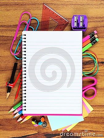 Blank lined notebook with underlying school supply frame on wood Stock Photo