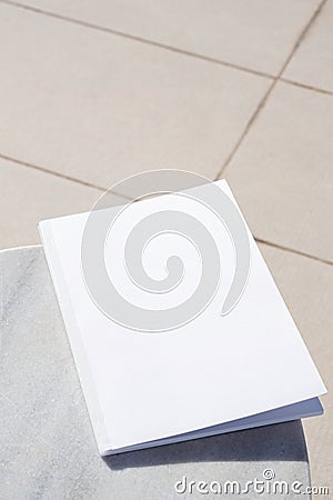 blank magazine for mockup design on marble table by the swimming pool Stock Photo