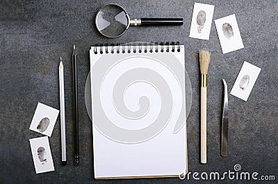 Blank notebook, fingerprint, magnifying glass, pencils and other tools for criminal investigation Stock Photo