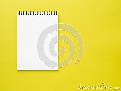 Blank notepad white page on yellow desk, color background. Top v Stock Photo