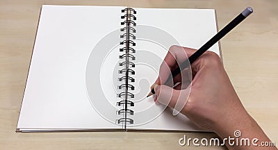 Blank Pages of Open Book with Asian Male Hand Holding Black Pencil ready to Write down Stock Photo