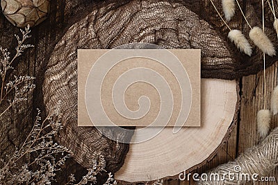 Blank paper card on a wooden table with dried plants Stock Photo