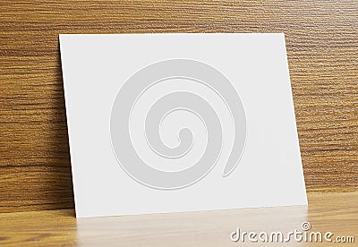 Blank a6 paper frame locked on wooden textured desk as template for graphic designers presentations, portfolios etc Stock Photo