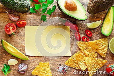 Blank paper and guacamole ingredients arranged as a frame on wooden background. Flat lay Stock Photo