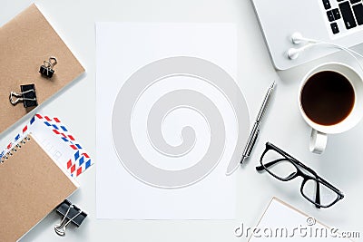 Blank a4 paper is in the middle of white office desk. Top view, flat lay Stock Photo