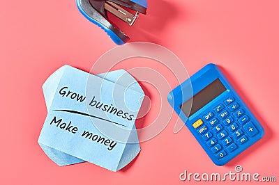 Blank paper sticker with words grow business make money near stationery items on pink desk Stock Photo