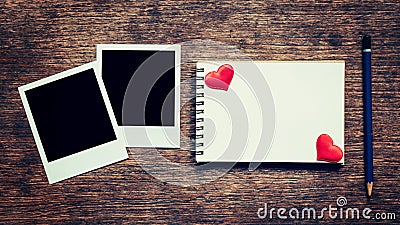 Blank photo frame, notebook, pencil and red heart on wood table Stock Photo