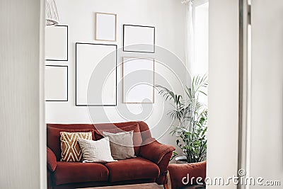 Blank picture frames mockups on white wall. White living room design. View of modern boho, scandi style interior with Stock Photo