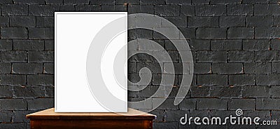 blank poster on wood table at black brick wall,perspective background Stock Photo