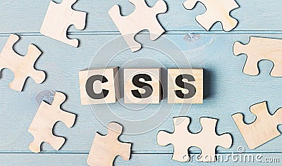 Blank puzzles and wooden cubes with the text CSS Cascading Style Sheets lie on a light blue background Stock Photo