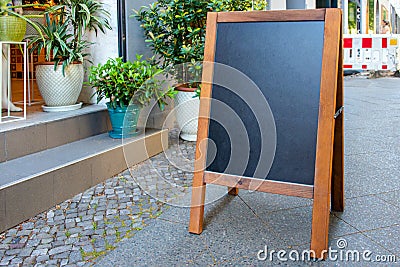 Blank restaurant shop sign or menu board near the entrance to restaurant or flower shop. Cafe menu on the street. Blackboard sign Stock Photo