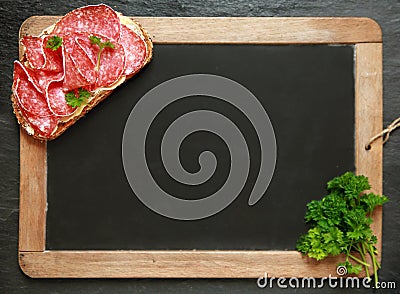 Blank school slate with a salami sandwich Stock Photo