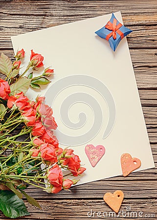 Blank sheet of paper on wooden surface with roses Stock Photo