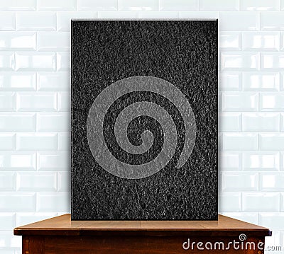 Blank stone frame on wood table at white ceramic tiles wall Stock Photo