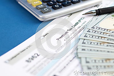 Blank tax form 8962 premium, pen, dollar bills, calculator. Concept of business and taxation. Selective focus Stock Photo
