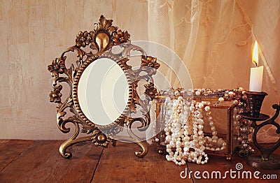 Blank vintage frame, pearls and burning candle Stock Photo