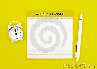 The Blank weekly plan notice block with alarm clock with yellow background. Empty schedule Stock Photo