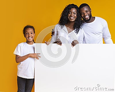 Blank white advertisement board in hands of happy black family Stock Photo