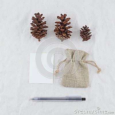 Blank white card, sackcloth bag, pinecones and black pen Stock Photo