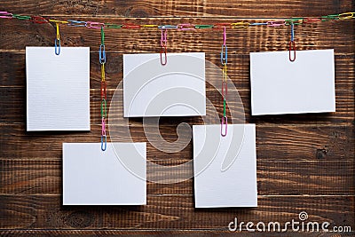 Blank white cards hanging on clip chain on a wooden background, a template for a photo collage, a concept of memories and a photo Stock Photo