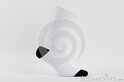 Blank white cotton long sock with black heel on invisible foot on white background as mock up for advertising, branding, design. Stock Photo