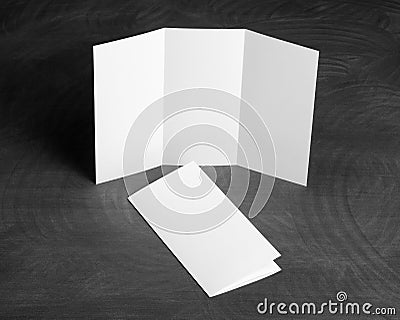 Blank white folding paper flyer on a black chalkboard Stock Photo