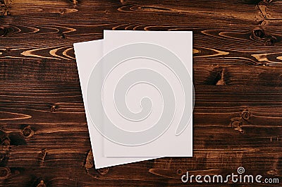 Blank white paper A4, envelope on vintage brown wooden board. Mock up for branding identity. Stock Photo