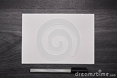 Blank white paper with pen on a wooden black desk. Close up Stock Photo