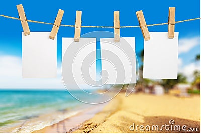 Blank white papers hanging on rope on beach Stock Photo