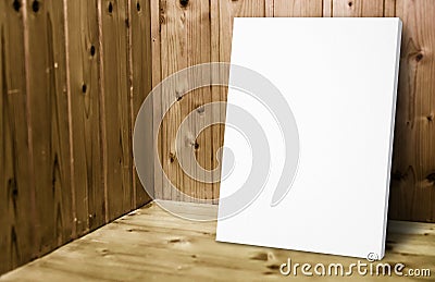 Blank white poster leaning at wooden wall in plank wood room,Mock up for adding your content. Stock Photo